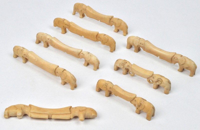 Zeven messenleggers van gesculpteerd ivoor, versierd met olifantjes. Kleine beschadigingen.