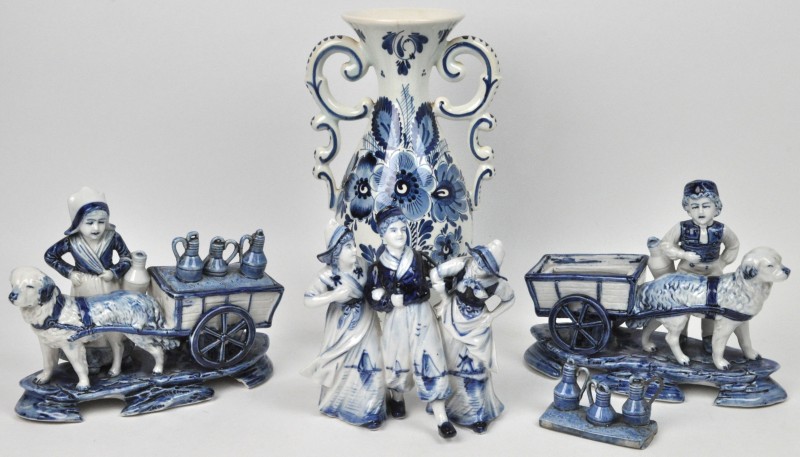 Een lot Delfts aardewerk, bestaande uit twee melkboerenhondenkarren, een balustervaasje en een groepje met drie personages.