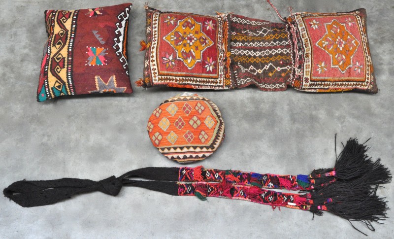 Een zadeltas, twee kussens en een halsversiering van wol. Arabisch werk.