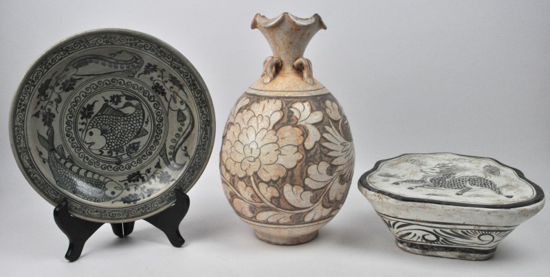 Een lot Aziatisch aardewerk, bestaande uit een eironde vaas met een decor van een paradijsvogel, een schotel met een vissendecor en een hoofdkussen met een fabeldier in het decor.