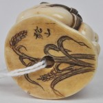 “Twee sumoworstelaars in actie”. Netsuké van gesculpteerd ivoor. Japan, Mei-ji. Onderaan gemerkt en versierd met gegraveerde korenaren.