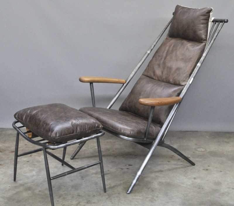 Een loungestoel met ottoman van metaal en bruin leder.