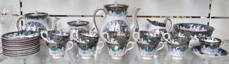 Een koffie- en theestel van meerkleurig aardewerk met een Cantondecor, bestaande uit elf kopjes en onderbordjes, een koffiepot, een theepot, een suikerpot, een melkkannetje en een kom.