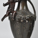 “Mignon”. Een driedelig klokstel van kunstbrons, bestaande uit een pendule en twee siervaasjes.