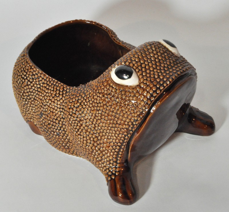 Een cachepot van bruin geglazuurd aardewerk in  de vorm van een kikker. Onderaan gesigneerd ‘Jean Roger’. Parijs.
