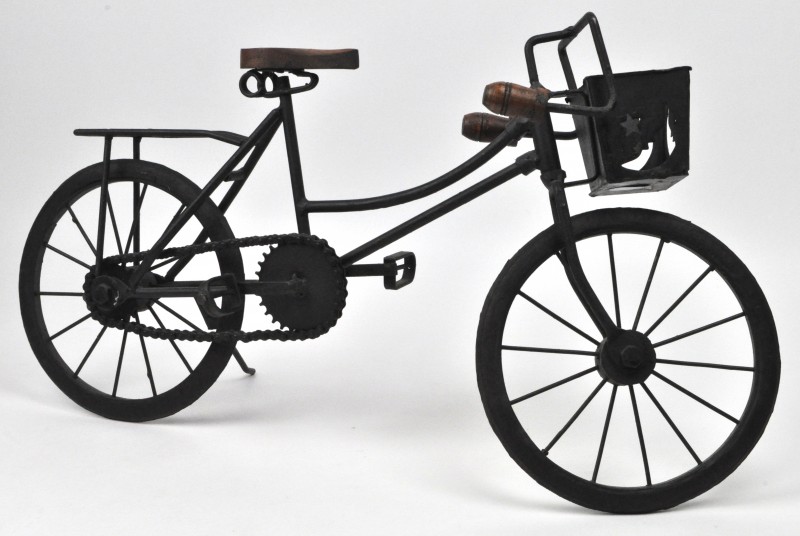 Een smeedijzeren fietsje met houten stuur en zadel.