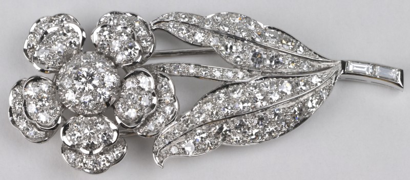 Een 18 karaats wit gouden broche in de vorm van een bloem bezet met diamanten en baguettes met een gezamenlijk gewicht van ± 2,00 ct.