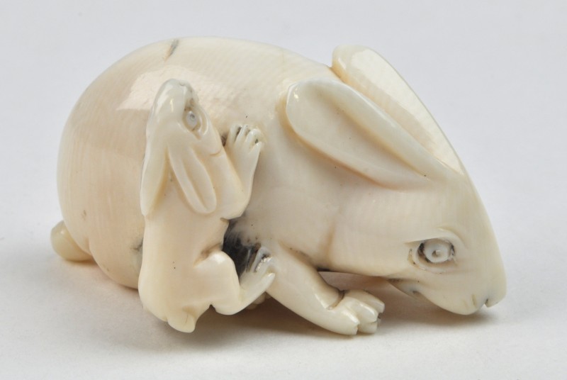 Een netsuke van gesculpteerd ivoor in de vorm van twee konijntjes.