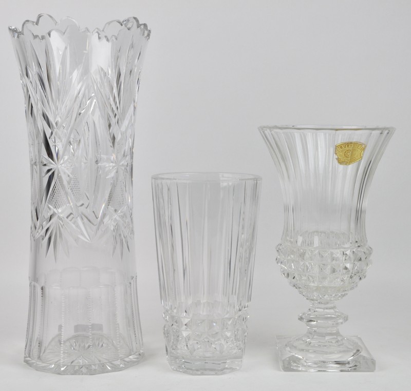 Een lot kleurloos kristal, bestaande uit een vaas op voet van Val St. Lambert, een Boheemse vaas en een kleiner model met een geribd motief.