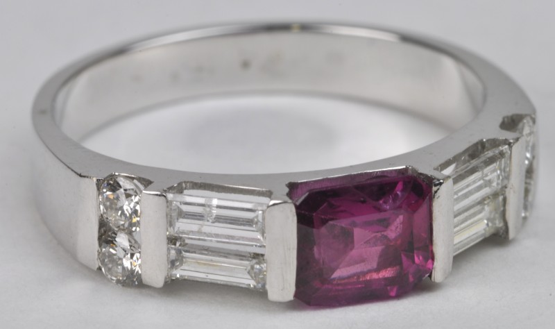 Een 18 karaats wit gouden ring bezet met diamanten en baguettes met een gezamenlijk gewicht van ± 0,70 ct. en een centrale robijn van ± 0,93 ct.
