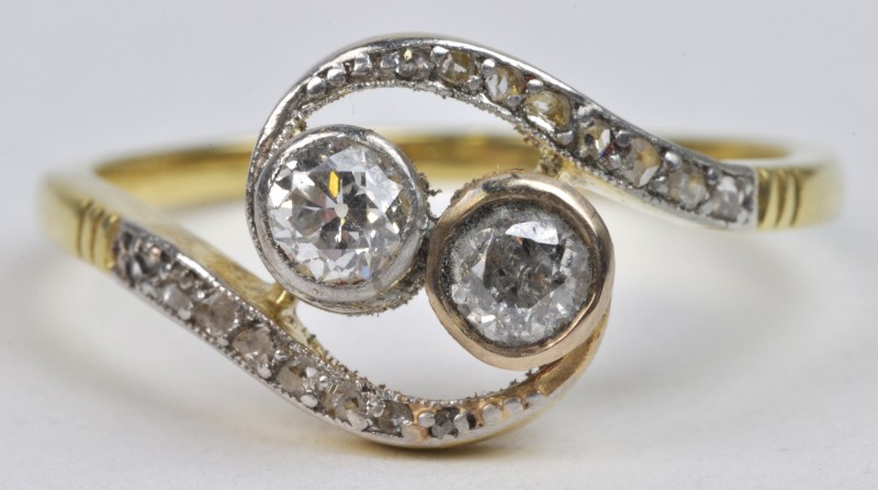 Een 18 karaats wit en geel gouden toi et moi ring bezet met diamanten met een gezamenlijk gewicht van ± 0,40 ct.