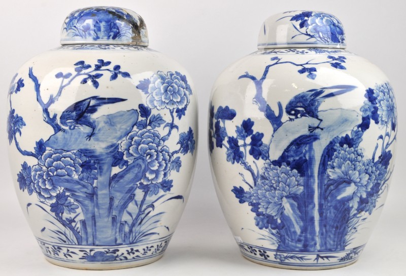 Een paar gemberpotten van Chinees porselein met een blauw op wit floraal decor. Restauratie aan één van de deksels. Onderaan gemerkt.