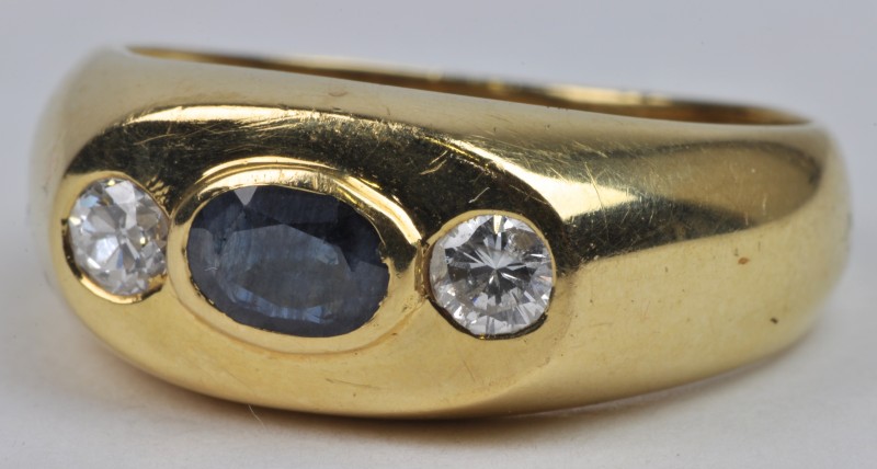 Een 18 karaats geel gouden ring bezet met diamanten met een gezamenlijk gewicht van ± 0,40 ct. en een centrale saffier van ± 0,40 ct.