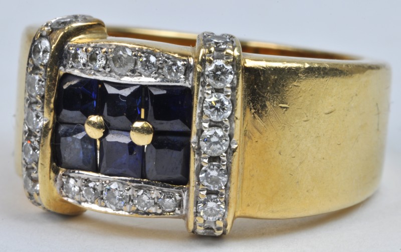 Een 18 karaats geel gouden ring bezet met diamanten met een gezamenlijk gewicht van ± 0,35 ct. en saffier baguettes met een gezamenlijk gewicht van ± 0,60 ct.
