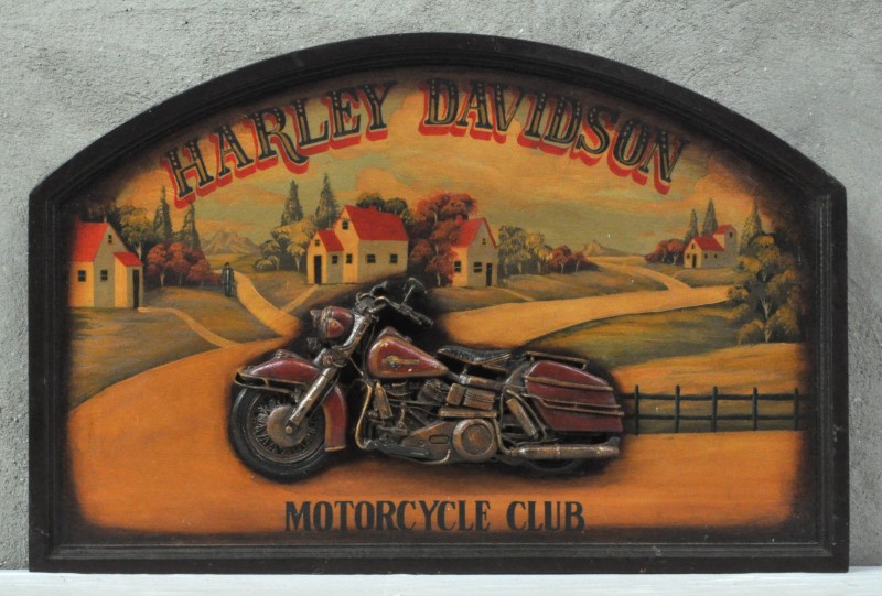 “Harley Davidson Motorcycle Club”. Een houten reclamepaneel met een motorfiets in reliëf. Naar de jaren ‘50.