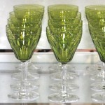 Een gedeeltelijk glasservies van geslepen kleurloos kristal, bestaande uit twaalf champagnecoupes, elf rode wijnglazen, elf aperitiefglazen en twaalf borrelglaasjes. We voegen er twaalf groengekleurde glazen van hetzelfde model aan toe. Vermoedelijk Val St. Lambert.