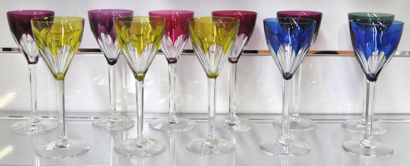 Een reeks van elf glazen van geslepen kristal, waarvan vijf mauve, drie geel, twee blauw en één groen gekleurd in de massa. Gemerkt.