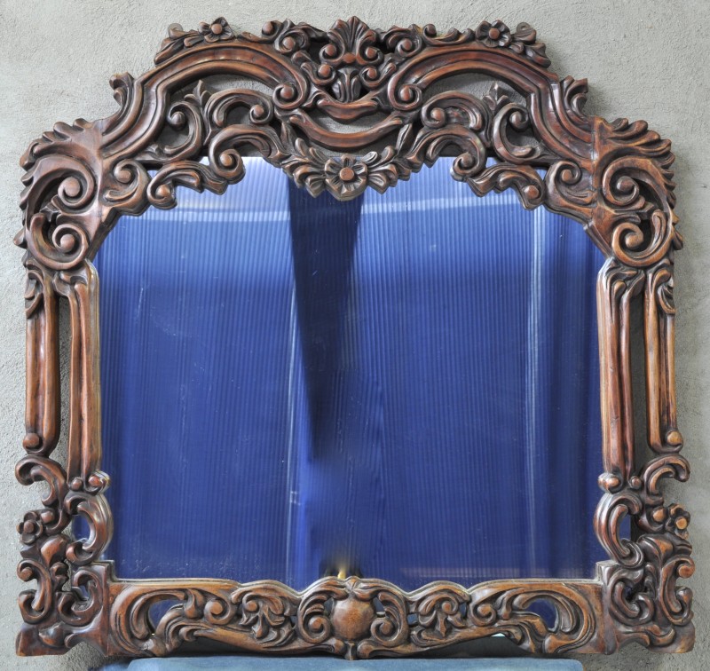 Een spiegel van gesculpteerd hout in de geest van de barok.