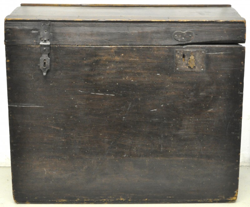 Een koffer van donkergepatineerd hout met smeedijzeren hengsels en handvatten.