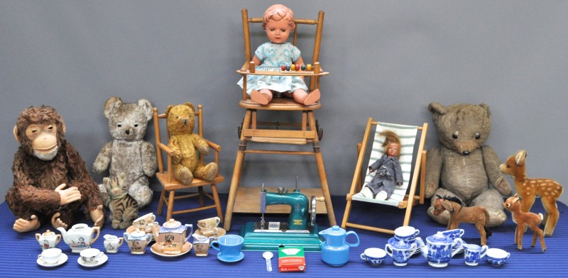 Een lot oud speelgoed, bestaande uit knuffeldieren, poppen, poppenstoeltjes, twee miniatuur theeserviesjes van porselein, een kinder filterset van Melitta, en een miniatuur naaimachine.