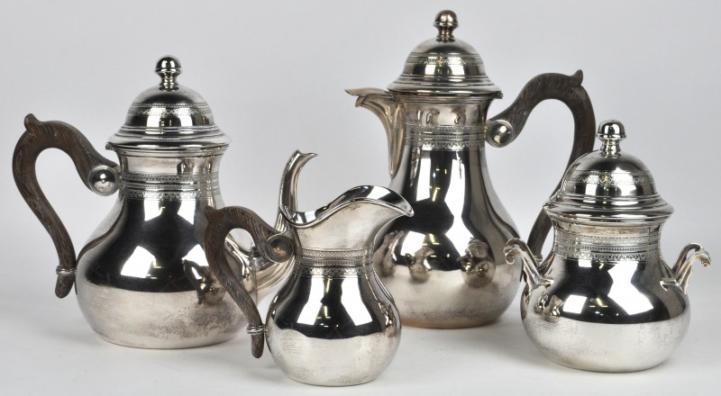 Een zilveren koffie- en theestel met houten handvatten, bestaande uit een koffiepot, een theepot, een roomkannetje en een suikerpot. 800‰.