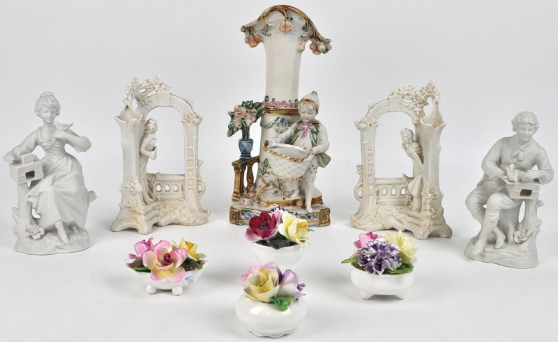 Een lot monochroom en meerkleurig biscuit bestaande uit drie beeldjes en twee fotokaders in de vorm van een romantisch koppel. We voegen er vier porseleinen bloemstukken aan toe.