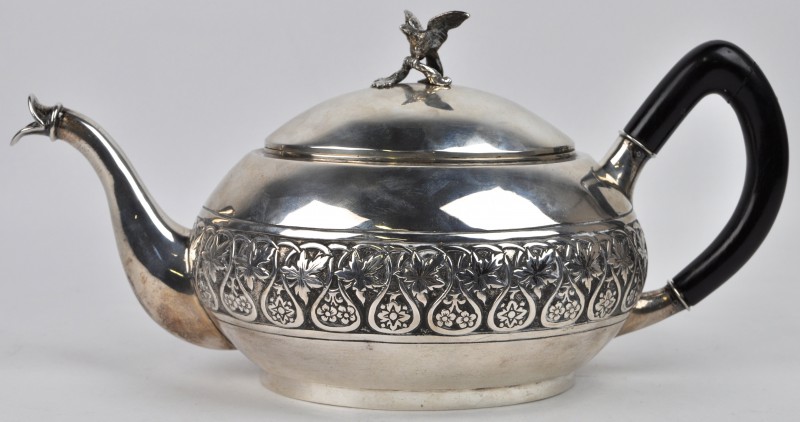 Een zilveren theepot met een houten handvat en het deksel getooid met een adelaar. XIXe eeuw.