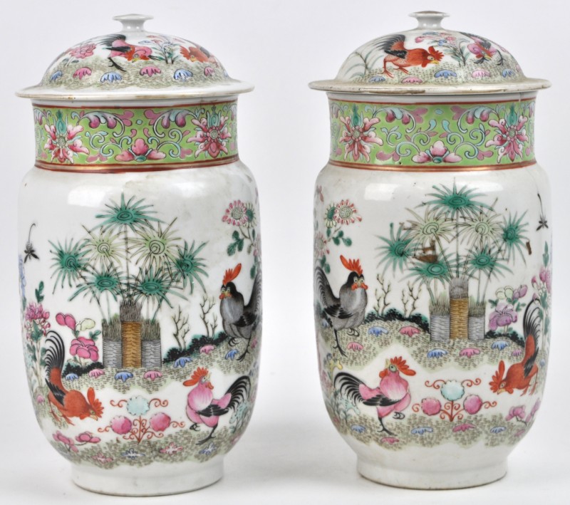 Een paar dekselvazen van meerkleurig Chinees porselein, versierd met een decor van hanen in een landschap. Haarscheur in één van de twee.