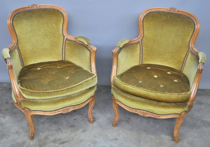 Twee fauteuils van gesculpteerd notenhout in Lodewijk XV-stijl, bekleed met groen fluweel.