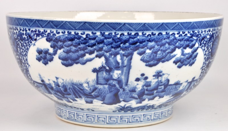 Een Chinese kom van blauw en wit porselein, versierd met een decor van zotjes.