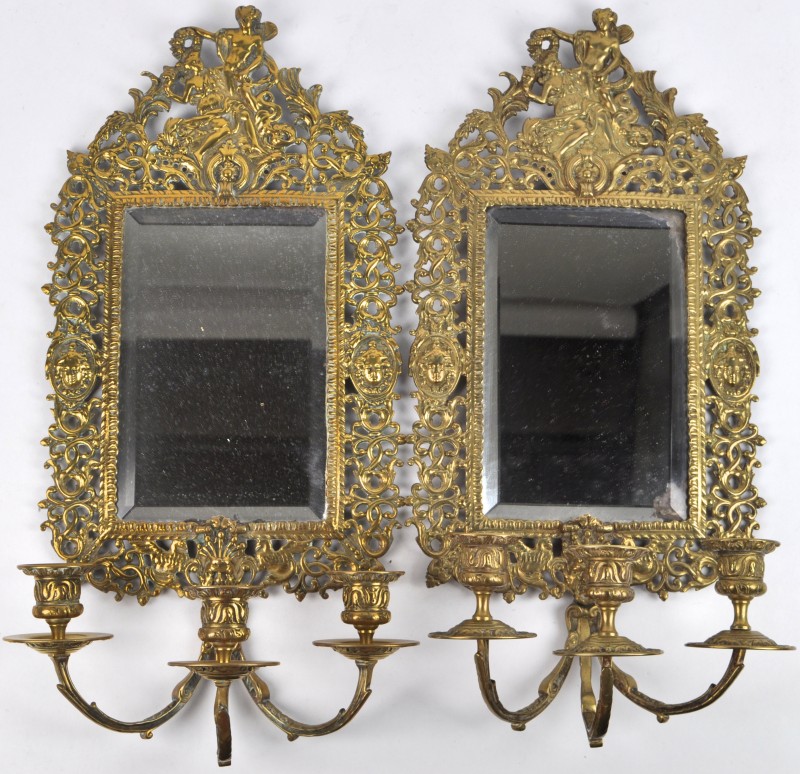 Een paar geelkoperen wandkandelaars in Lodewijk XIV-stijl met drie lichtpunten en een spiegeltje.
