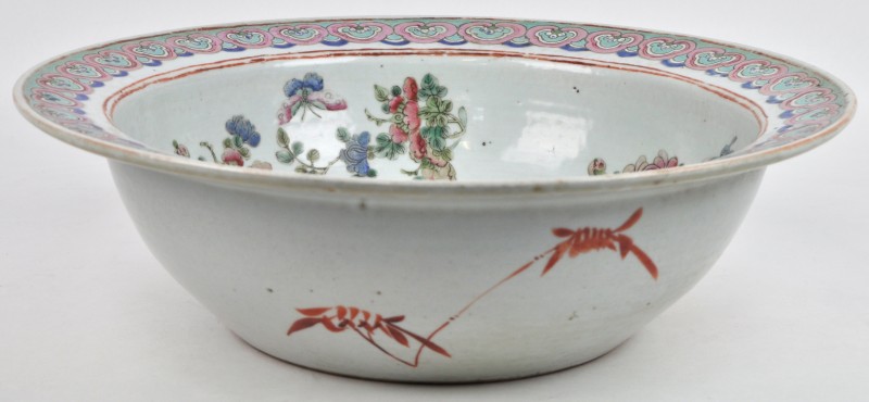 Een ronde kom van veelkleurig Chinees porselein met brede platte rand. Decor van het interieur met slijtage. XIXde eeuw.