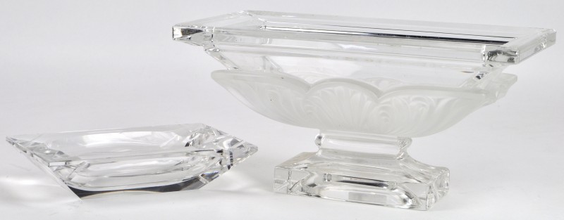 Een rechthoekige coupe en een asbak van kleurloos geslepen kristal. Het eerste met gesatineerd decor in de geest van Lalique, de tweede gemerkt Val St. Lambert.