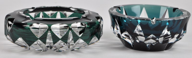 Twee verschillende asbakken van geslepen kristal, groen gekleurd in de massa. Gemerkt.