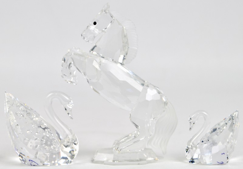 Een stijgerend paardje met gesatineerde staart en manen en twee zwaantjes van geslepen kleurloos kristal.