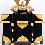 Een miniatuur replica van een Samourai-outfit met zwartgelakte opbergkoffer en certificaat.