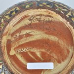 Een kalebasvaasje van meerkleurig aardewerk met een bloemendecor. Italiaans werk. Onderaan gesigneerd.