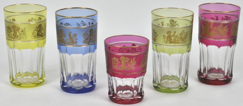 Een serie van vijf glaasjes van kleurloos kristal en versierd met een gouden rand.