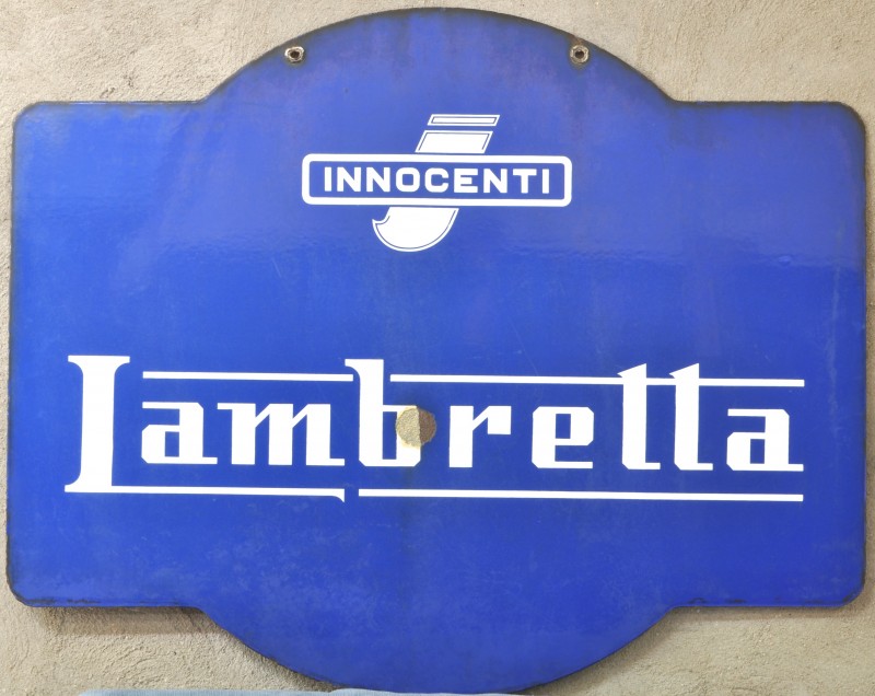 Een oude reclamepaneel van geëmailleerd metaal met opschrift “Lambretta”. Jaren ‘50.