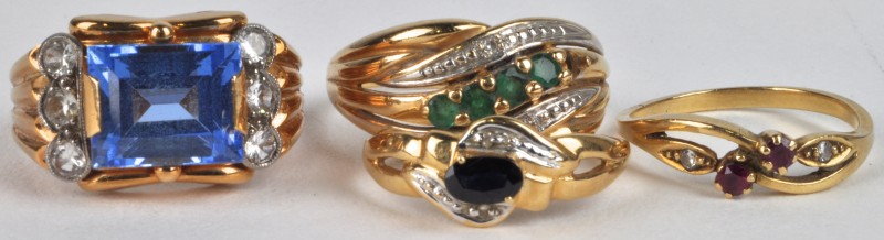 Vier verschillende ringen van 18 karaats geel goud bezet met edelstenen en halfedelstenen.
