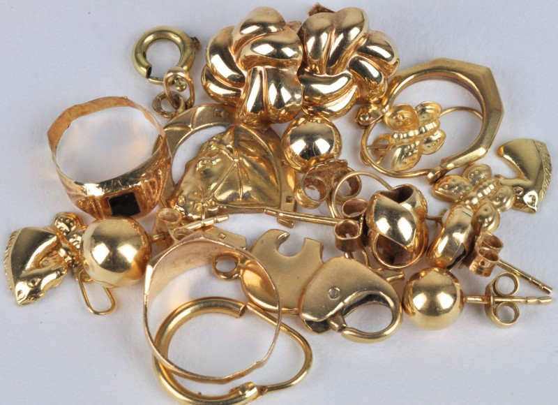 Een lot 18 karaats geel goud waaronder oorbellen, hangertjes, ringetjes en een slot.