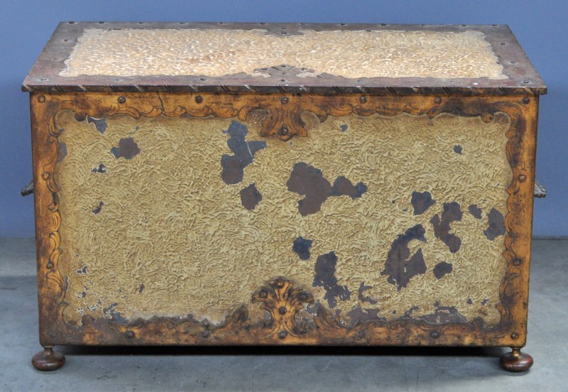 Een kleine koffer van wit en goud gepatineerd ijzer met twee handgrepen in de vorm van een schelp.
