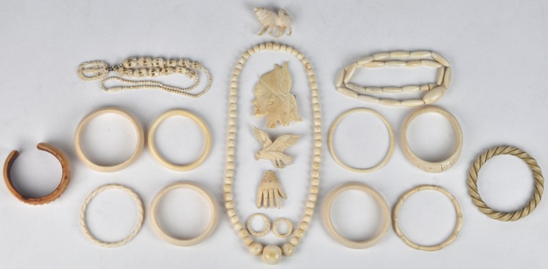 Een lot ivoren juwelen bestaande uit armbanden, halssnoeren, broches en ringen. e.a.