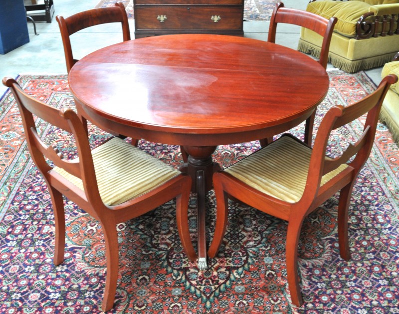Een ronde tafel en vier bijbehorende stoelen in Engelse stijl. XXe eeuw.