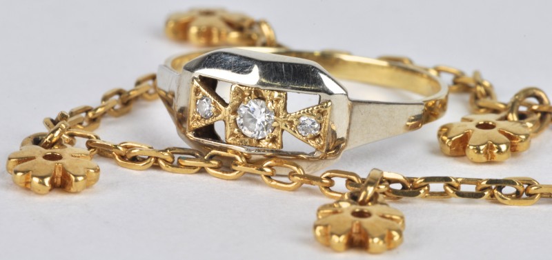 Een 18 karaats wit en geel gouden ring bezet met briljanten met een gezamenlijk gewicht van ± 0,10 ct. En een 18 karaats geel gouden armband met bloemvormige hangers.