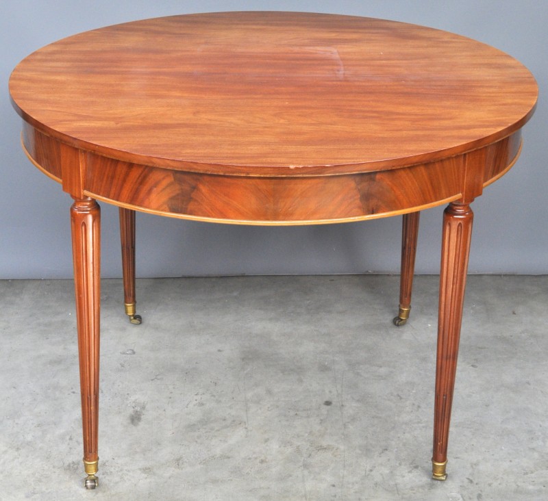 Een ronde tafel van gefineerd hout in Lodewijk XVI-stijl.