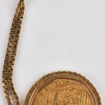 Een 18 karaats geel gouden ketting met hanger bezet met een munt met voorstelling van een  wapenschild.