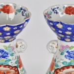 Een paar vazen van Chinees porslein met een meerkleurig decor van personages en bloemen en versierd met twee olifantjes. Onderaan gemerkt.