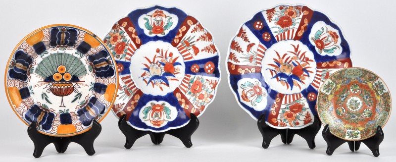Een lot borden bestaande uit twee van Imari porselein, één van Delfts aardewerk met pauwdecor en één Chinees met Cantondecor.