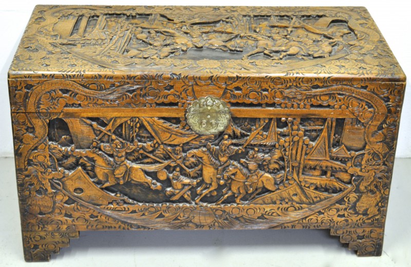 Een Chinese koffer versierd met een gesculpteerd krijgersdecor op de vier zijden.